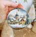 a person holding a christmas ornament in their hand