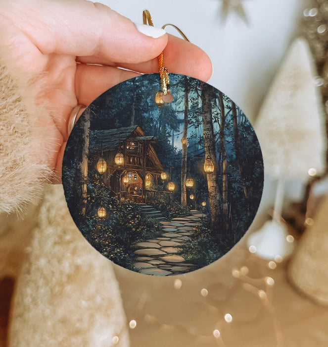a person holding a christmas ornament with a house on it