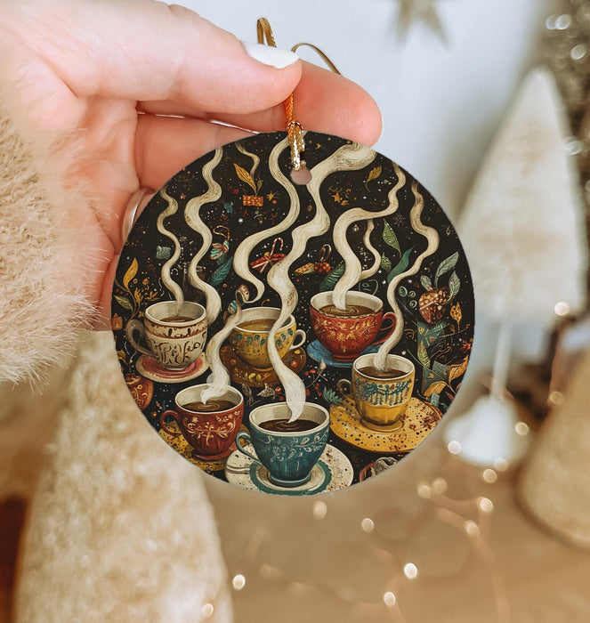 a person holding a christmas ornament with coffee cups on it