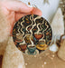 a person holding a christmas ornament with coffee cups on it