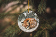 a glass ornament with a sleeping fox on it