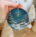 a person holding a christmas ornament in their hand