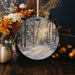 a christmas ornament with a picture of a snowy forest