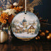 a christmas ornament with a picture of a village on it