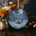 an ornament with a picture of an eagle flying over a snowy mountain