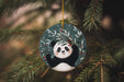 a panda bear ornament hanging from a christmas tree