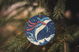 a blue ornament hanging from a christmas tree