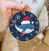 a person holding a christmas ornament in their hand