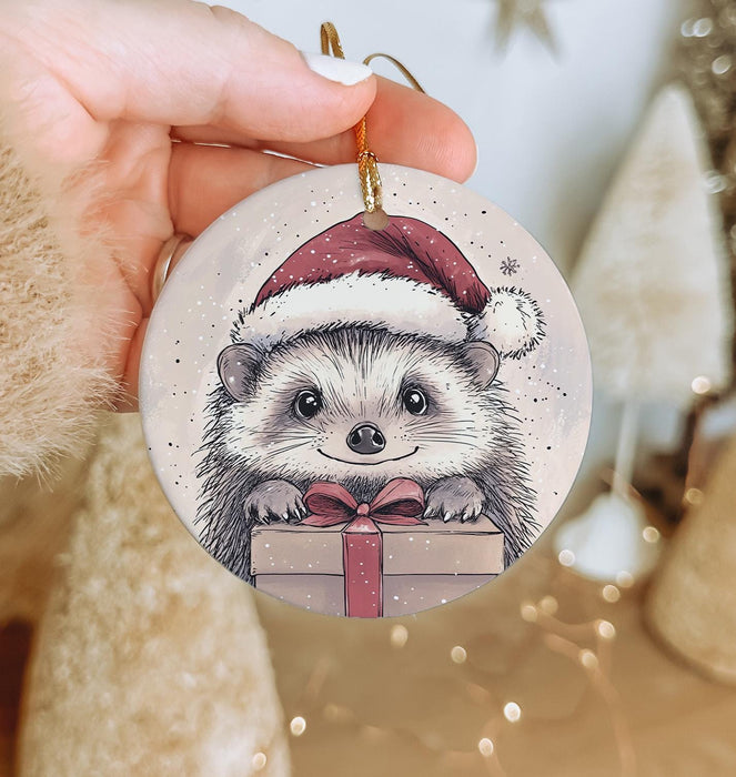 a hand holding a christmas ornament with a hedge on it