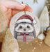 a hand holding a christmas ornament with a hedge on it
