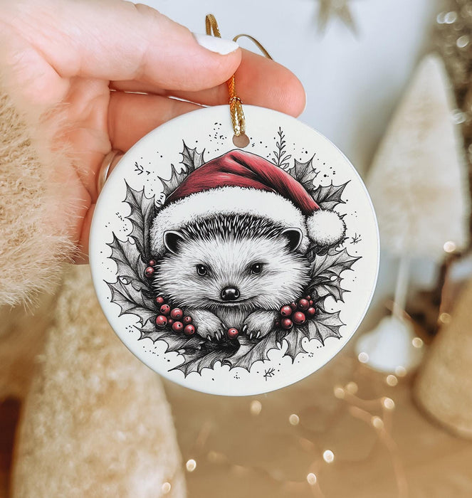 a hand holding a christmas ornament with a hedge on it