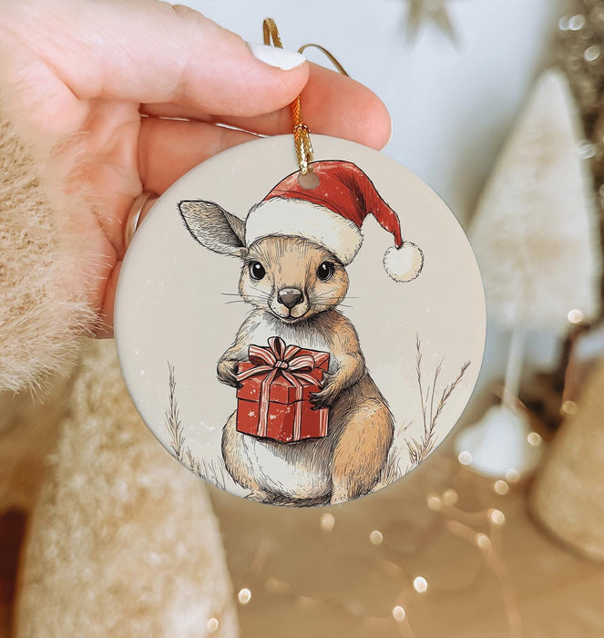 a hand holding a christmas ornament with a picture of a bunny holding a