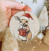 a hand holding a christmas ornament with a picture of a bunny holding a
