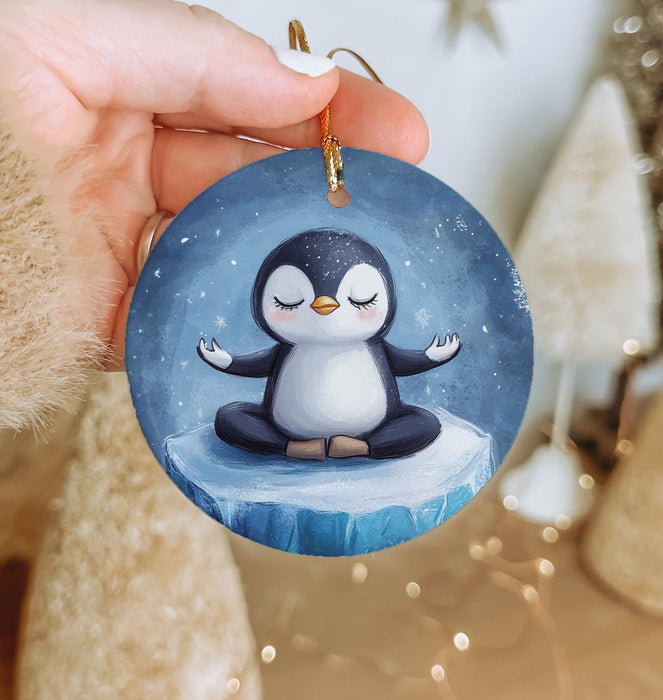 a person holding a penguin ornament in their hand
