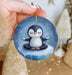 a person holding a penguin ornament in their hand