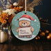 a christmas ornament with a teddy bear holding a sign