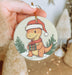 a person holding a christmas ornament in their hand
