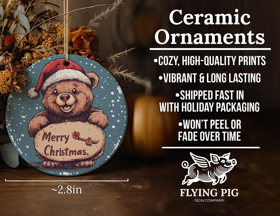a ceramic christmas ornament with a teddy bear holding a sign