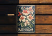 a bathroom sign with flowers painted on it