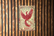 a picture of a red bird on a wooden wall