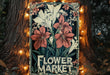 a flower market sign on a tree with lights