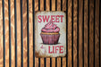 a sign that says sweet life with a cupcake on it