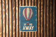 a sign that says up and away on a wooden wall