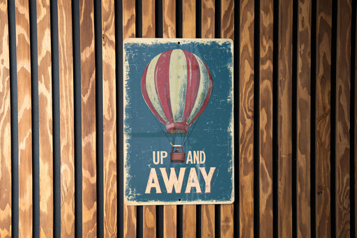 a sign that says up and away on a wooden wall