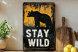 a sign that says stay wild on a shelf