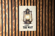 a light the way sign on a wooden wall