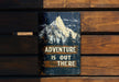 a sign on a wooden bench that says adventure is out there