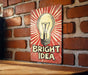 a bright idea sign on a brick wall