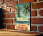 a picture of a welcome to paradise sign on a brick wall