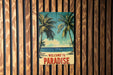 a welcome to paradise sign on a wooden wall