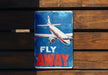 a sign that says fly away on a wooden wall