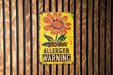 a yellow sign with a flower on it on a wooden wall