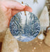 a person holding a christmas ornament in their hand