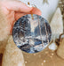 a person holding a christmas ornament in their hand