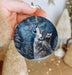 a person holding a ornament with a wolf on it