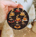a person holding a christmas ornament with coffee cups on it