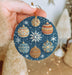 a person holding a christmas ornament in their hand