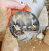 a person holding a christmas ornament in their hand
