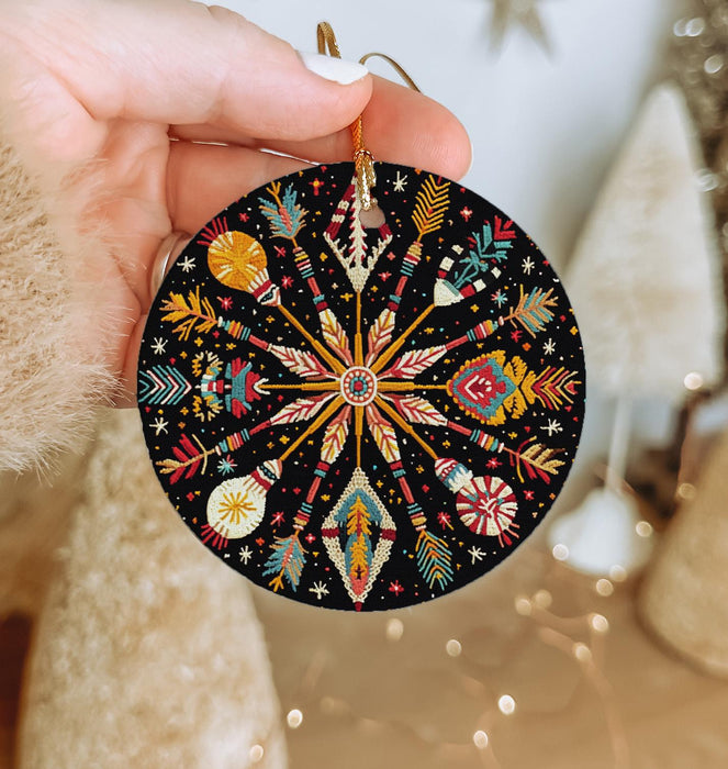 a hand holding a black ornament with colorful designs
