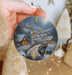 a person holding a christmas ornament in their hand