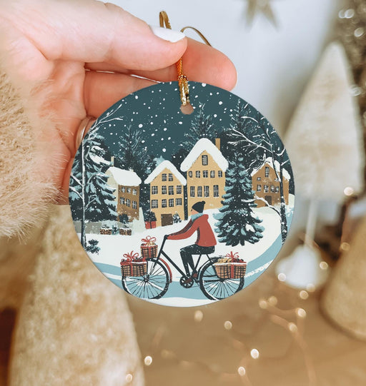 a person holding a christmas ornament with a bicycle on it