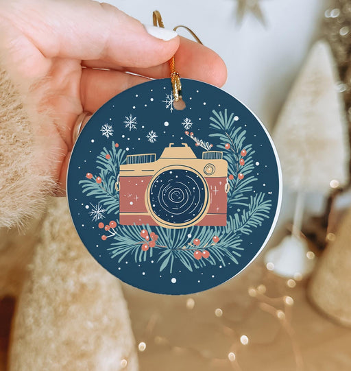 a person holding a christmas ornament with a camera on it