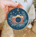 a person holding a christmas ornament with a camera on it