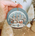 a person holding a christmas ornament in their hand