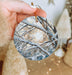 a person holding a christmas ornament in their hand
