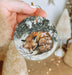 a hand holding a christmas ornament with a picture of a fox